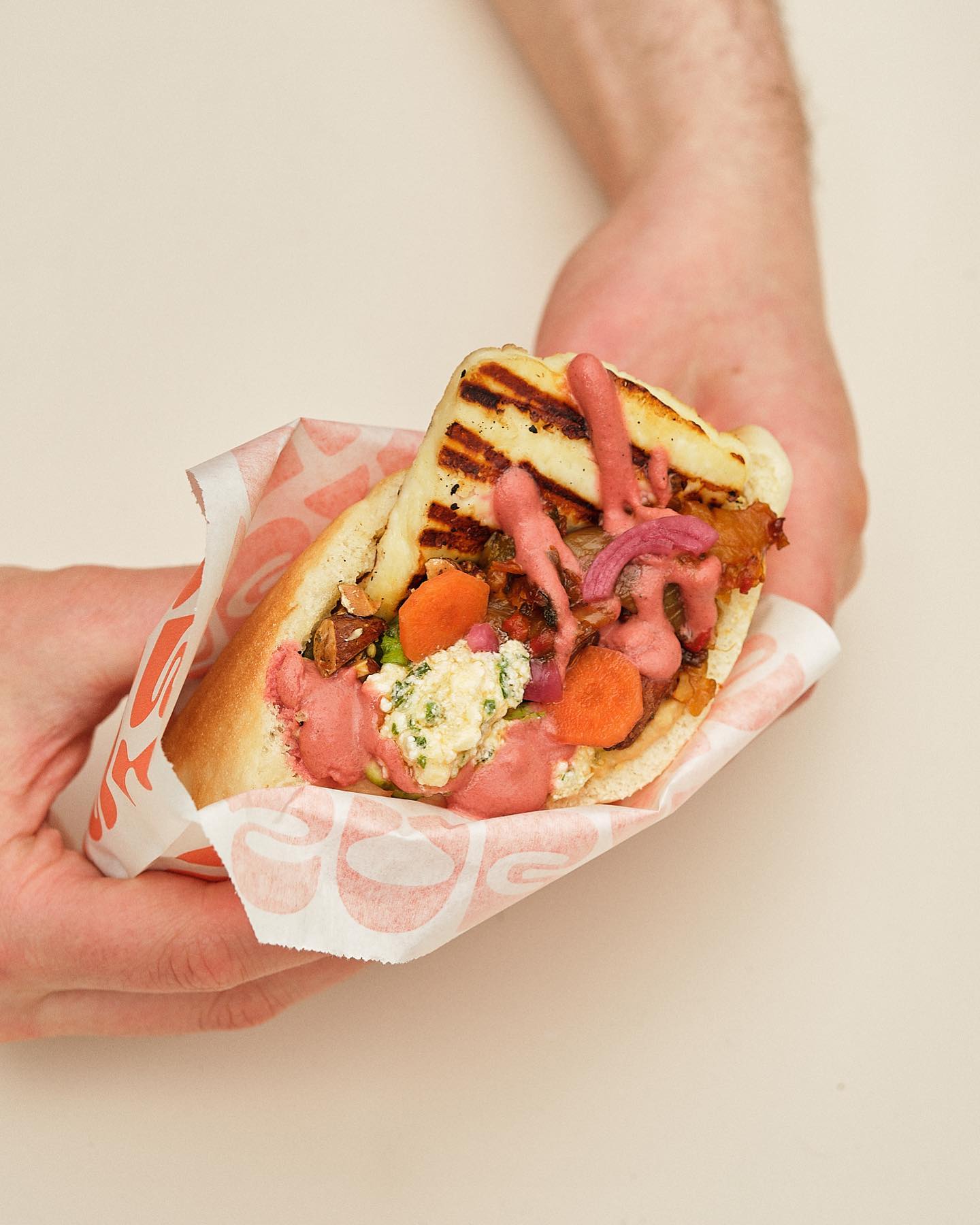 Custom printed burger bag holding a pita filled with fresh ingredients