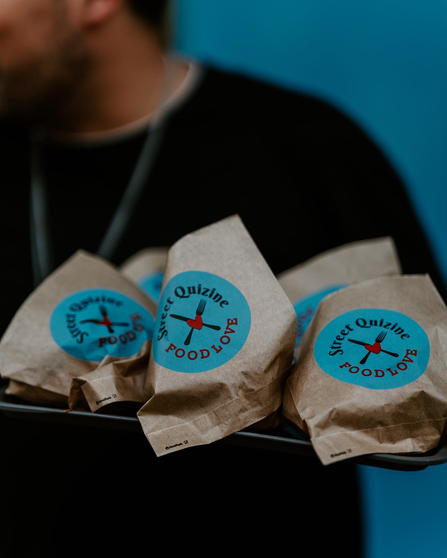 Brown burger bags with logo and vibrant design, served on a tray